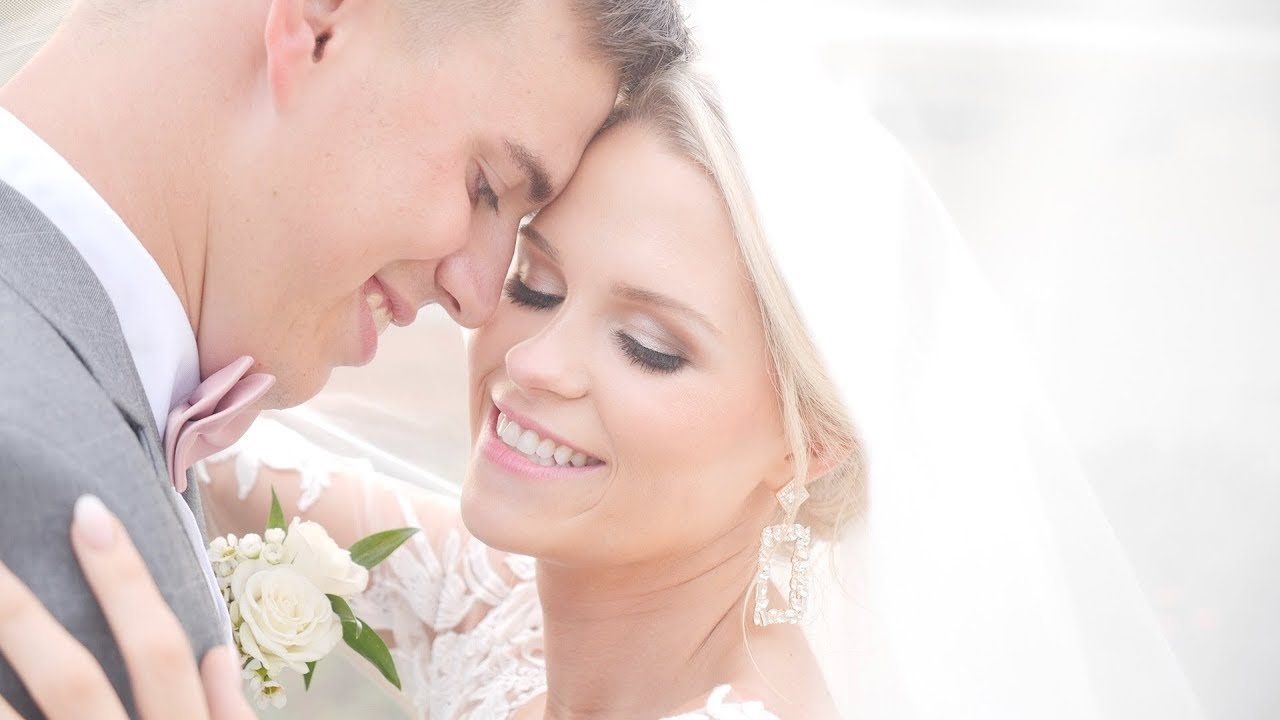 An affectionate couple smiling closely together on their wedding day.